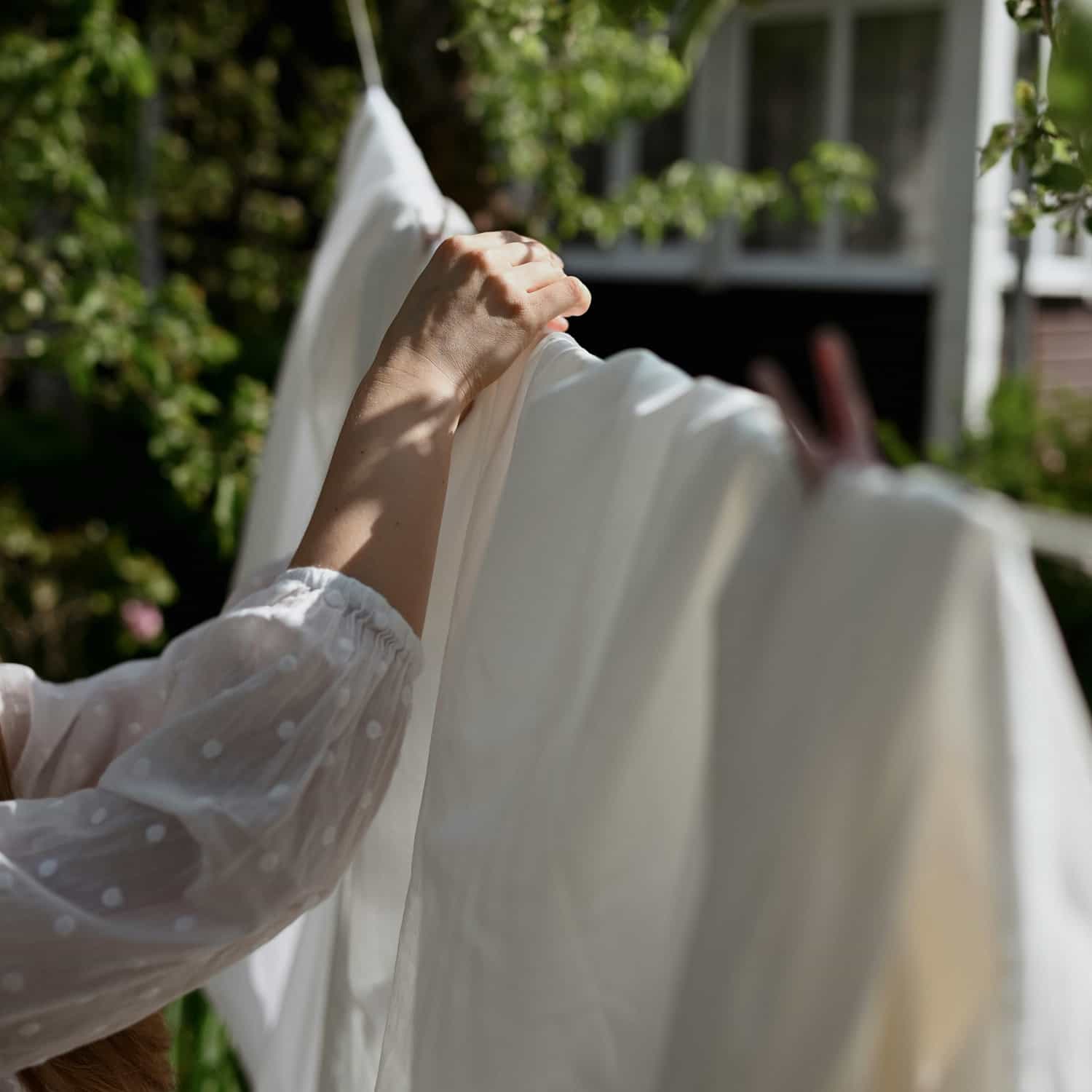 Une femme étend du linge blanc