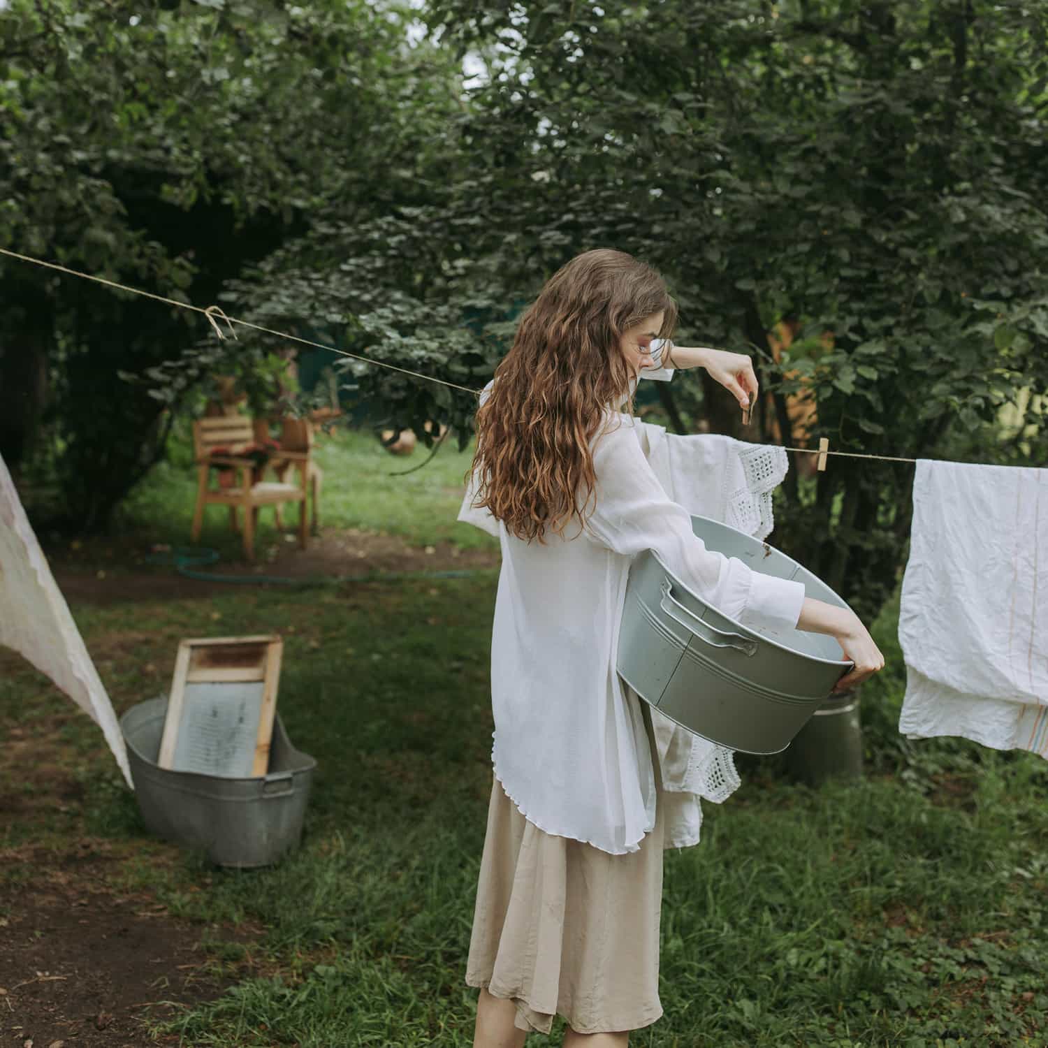 Une femme étend le linge dans le jardin