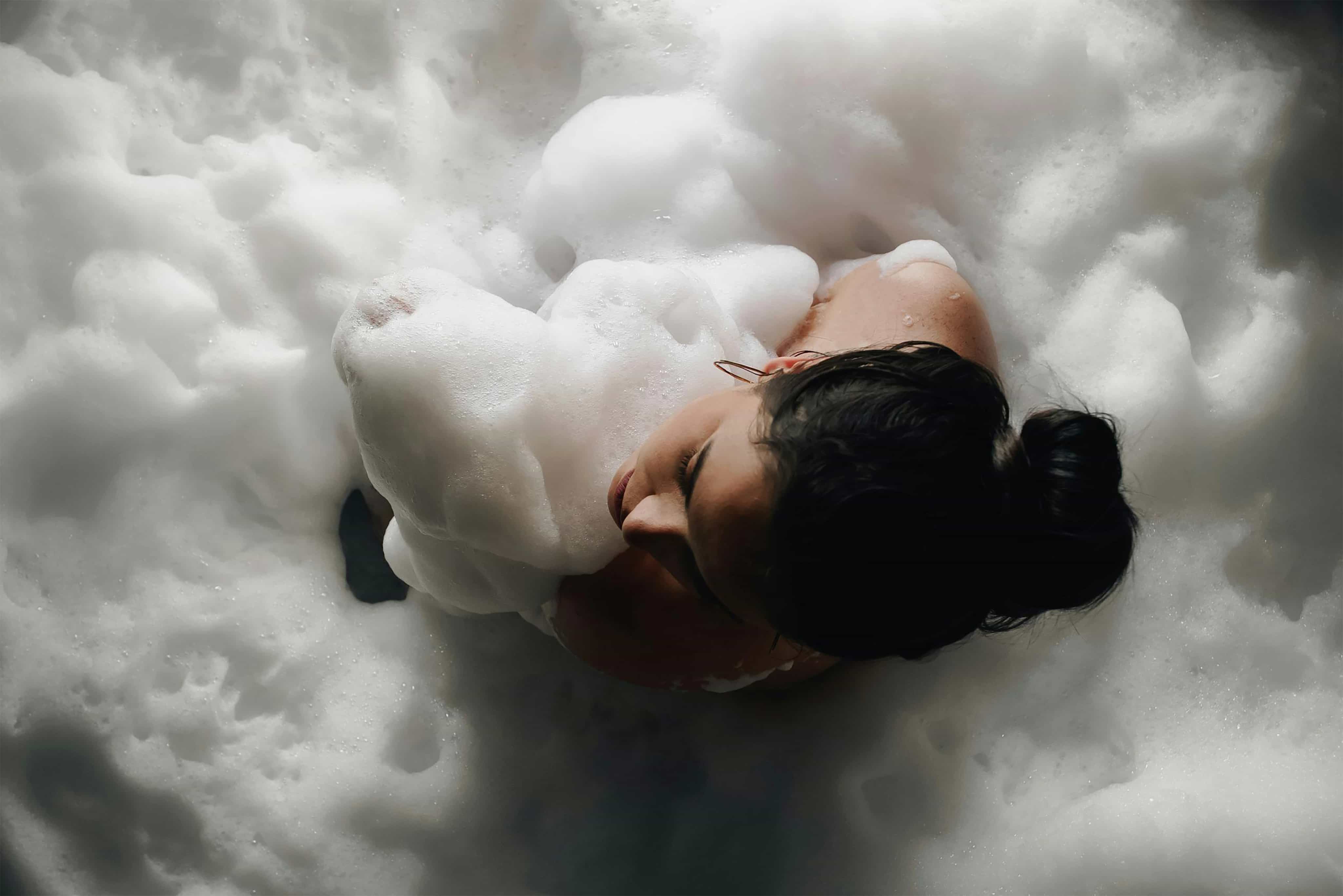 Une femme prend un bain de mousse